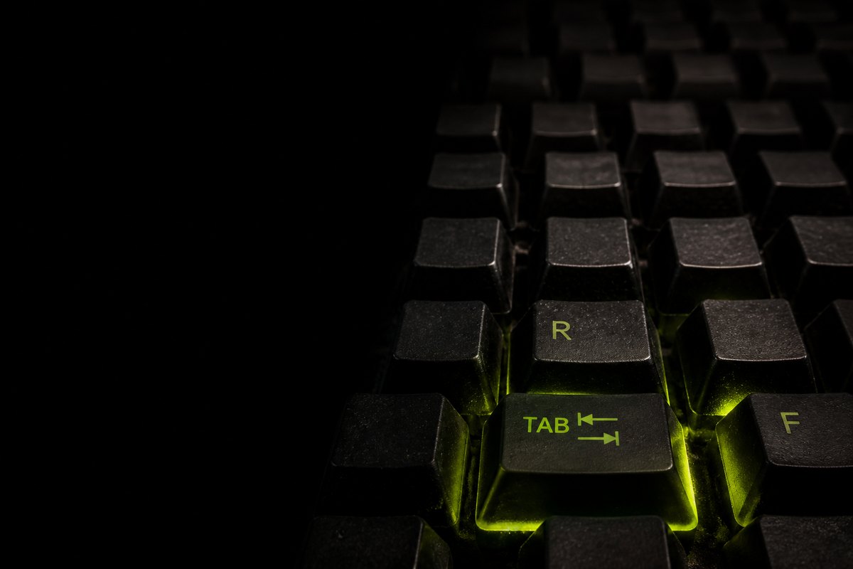 A darkened keyboard with the TAB and R keys lit from beneath